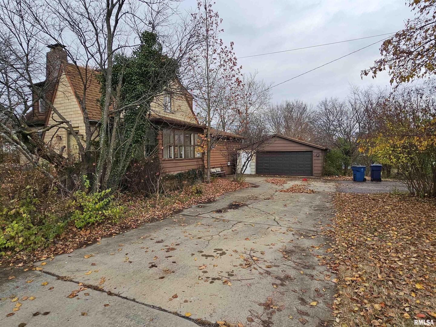 a backyard of a house with large trees and wooden fence
