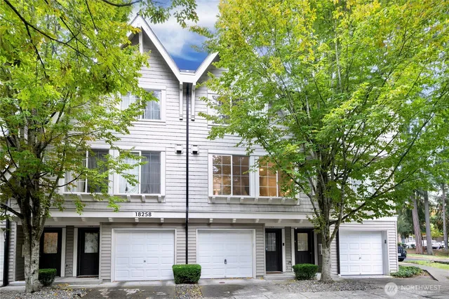 a front view of a house with a tree