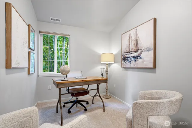 a view of a workspace with furniture and a window