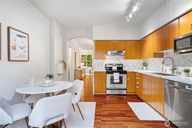 a kitchen with stainless steel appliances granite countertop a sink and a refrigerator