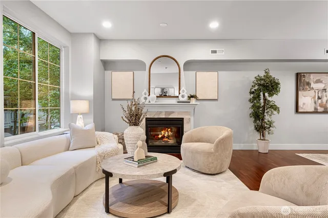 a living room with furniture potted plant a fireplace and a window