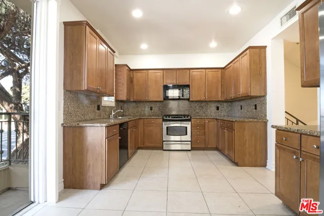 a kitchen with a refrigerator sink and cabinets