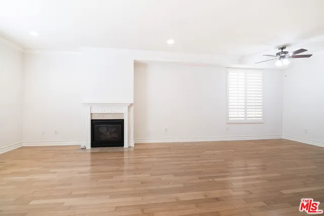 a view of an empty room with a fireplace and a window