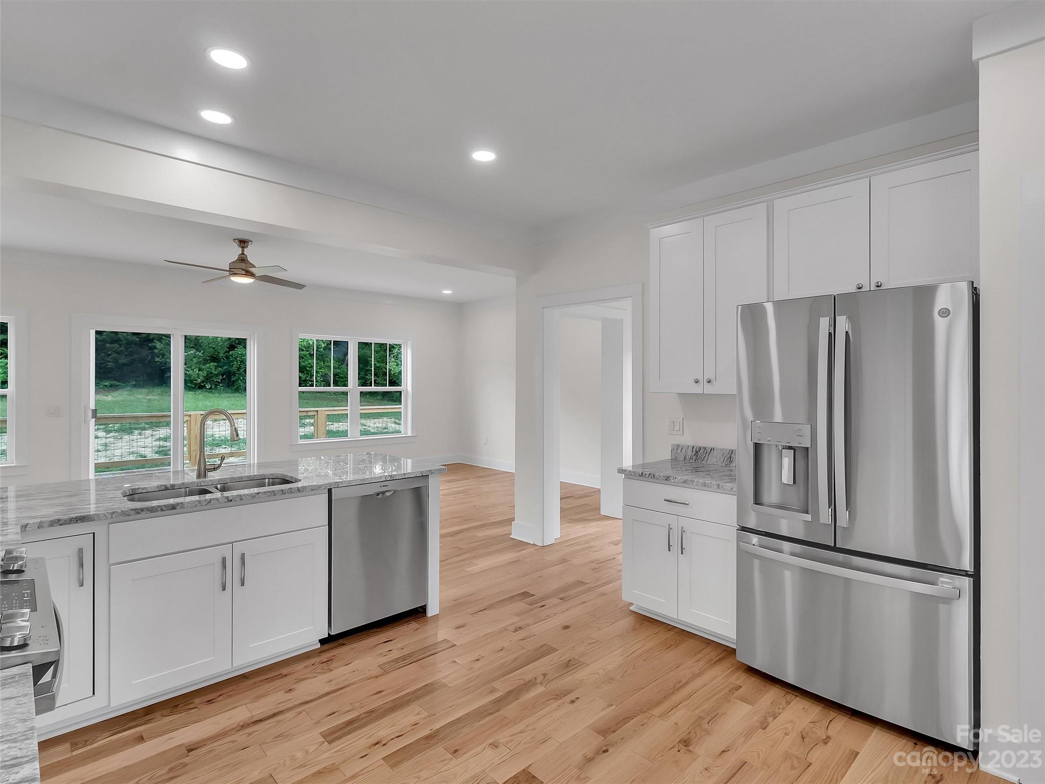 160 Rdg Vw Drive, Unit 21 Clyde, NC 28721 - Photo 13 of 39 a kitchen with a refrigerator a sink and dishwasher with wooden floor