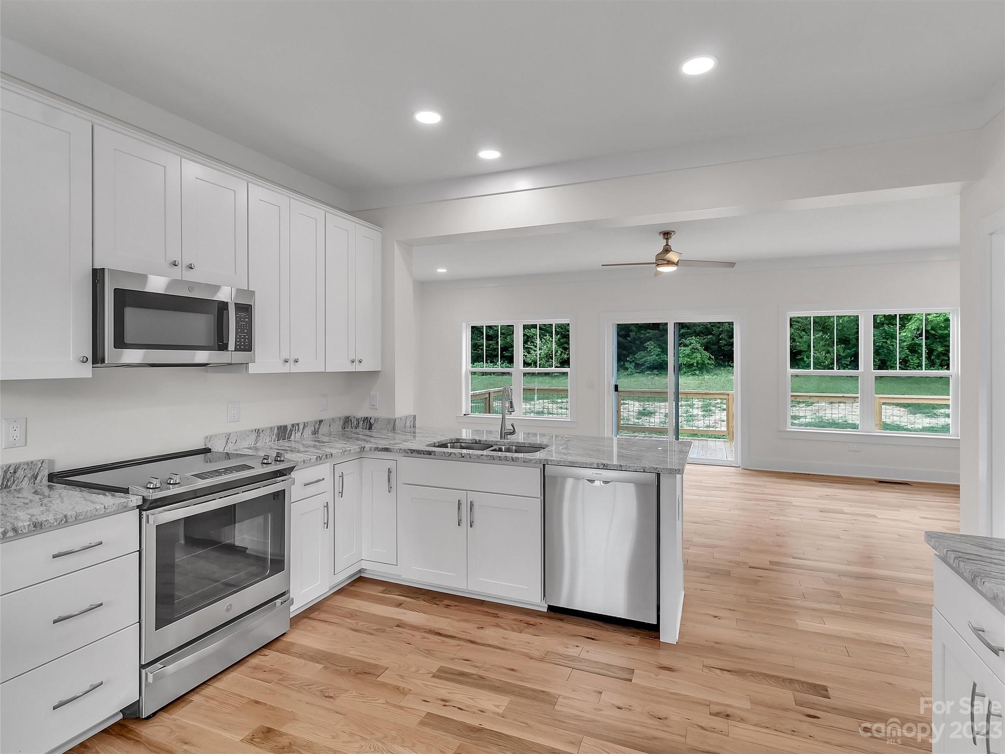 160 Rdg Vw Drive, Unit 21 Clyde, NC 28721 - Photo 14 of 39 a kitchen with stainless steel appliances granite countertop a stove a sink and a microwave