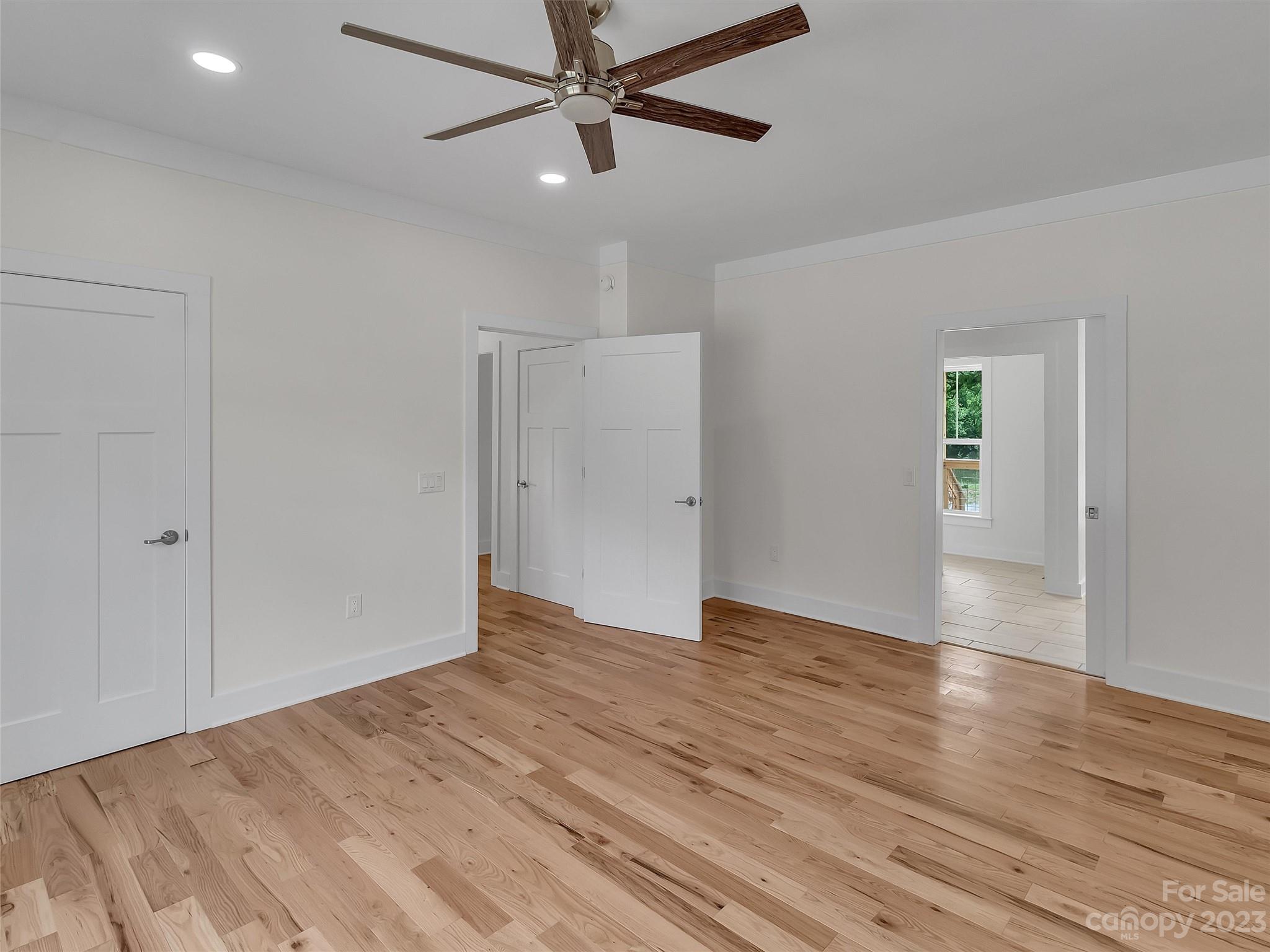 160 Rdg Vw Drive, Unit 21 Clyde, NC 28721 - Photo 22 of 39 an empty room with wooden floor closet and fan