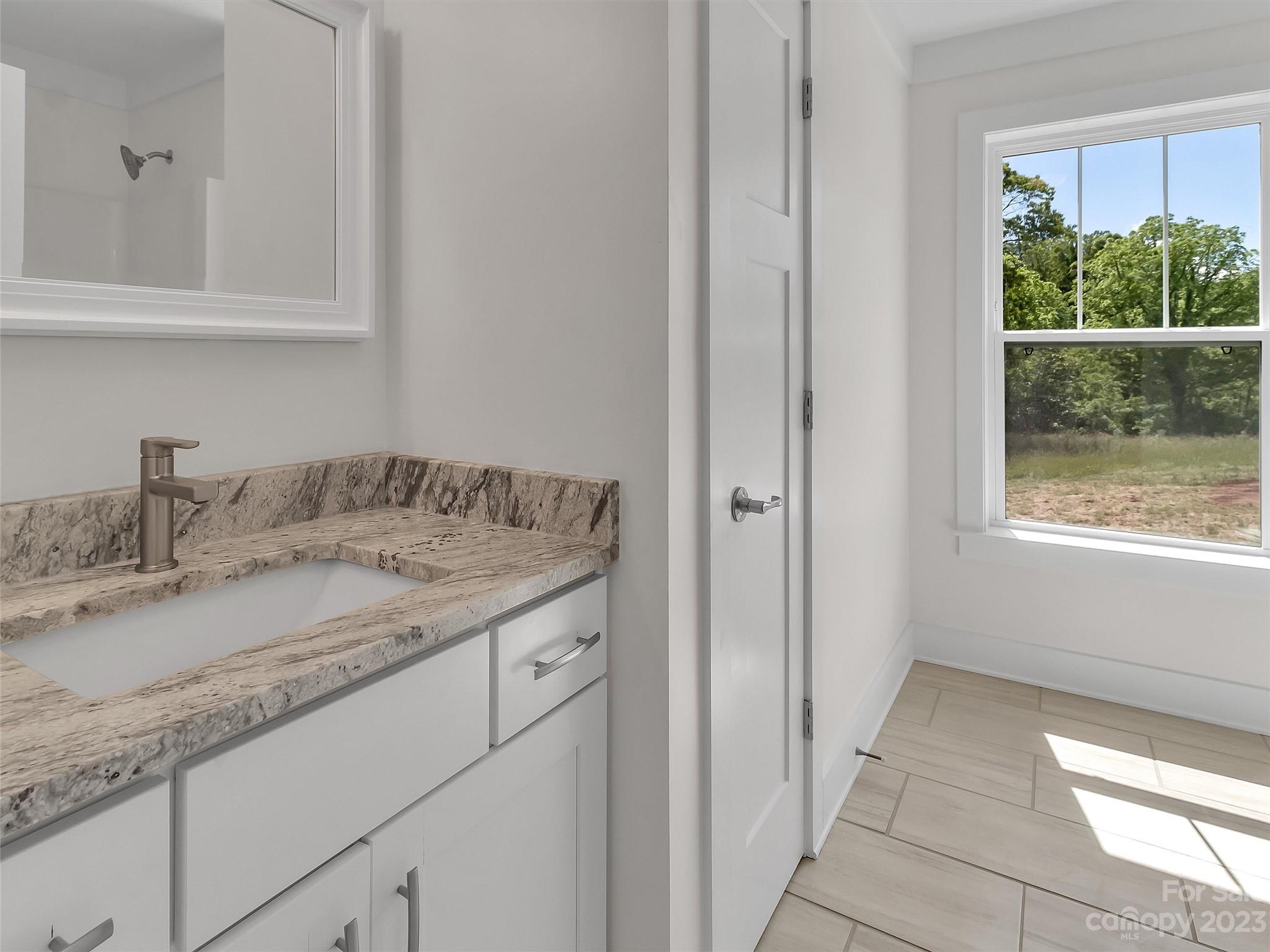 160 Rdg Vw Drive, Unit 21 Clyde, NC 28721 - Photo 30 of 39 a bathroom with a granite countertop sink and a mirror