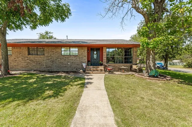 a view of a house with backyard and sitting area
