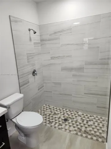 a bathroom with a toilet and a shower