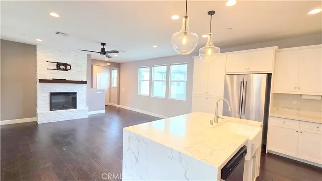 a kitchen with kitchen island a sink stainless steel appliances and wooden floor