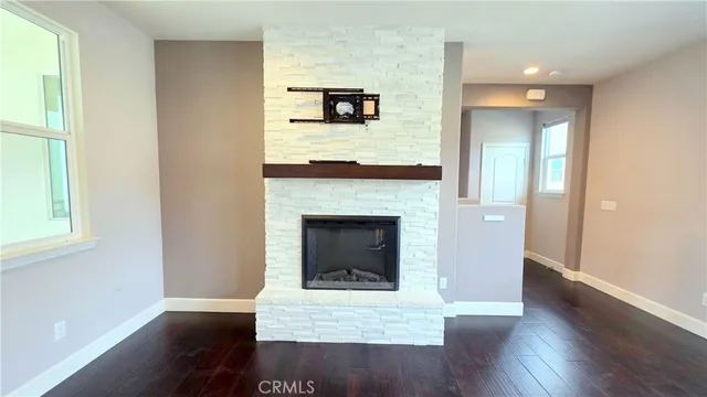 a living room with a fireplace and wooden floor