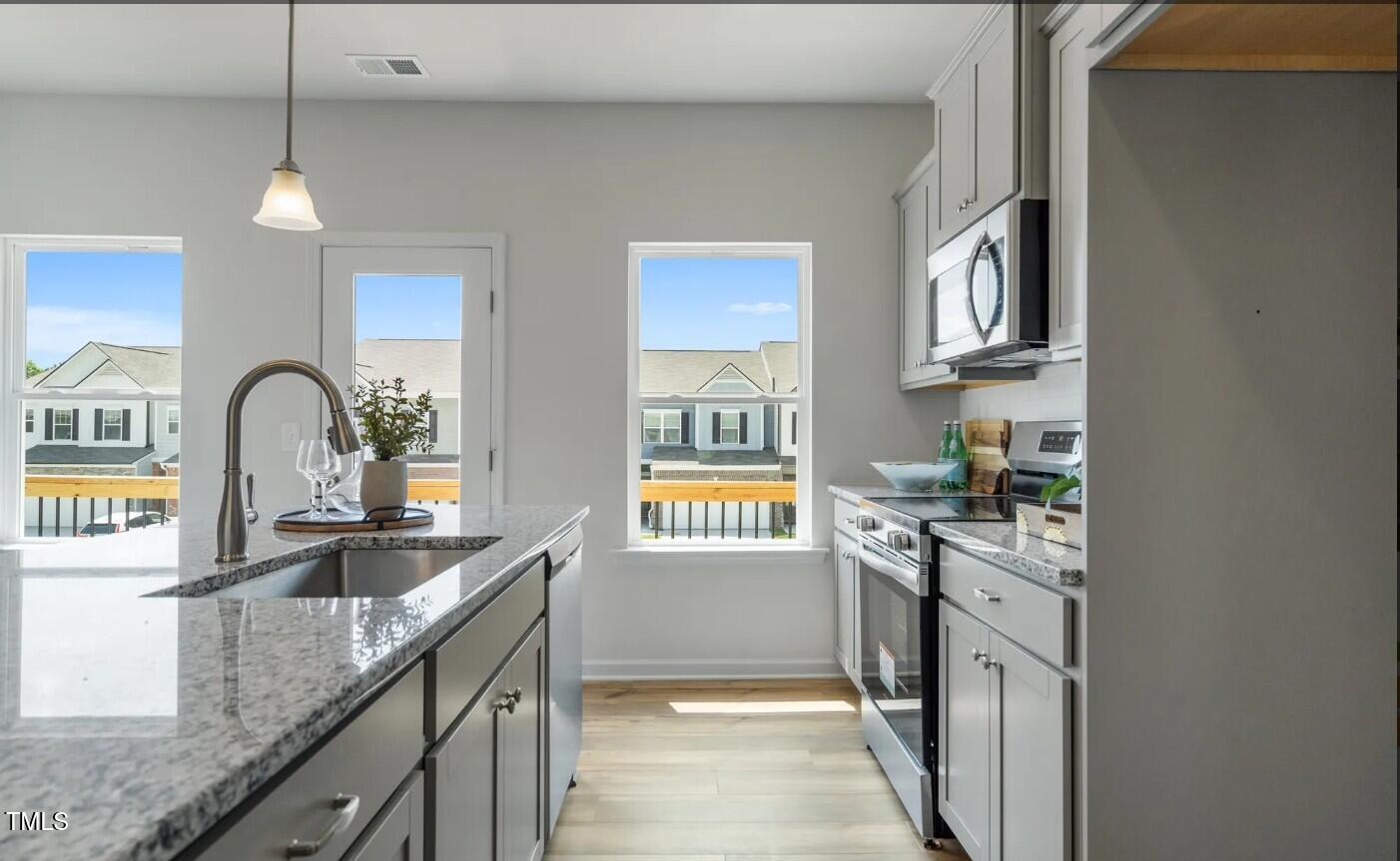 724 Orch Vista Circle Raleigh, NC 27606 - Photo 5 of 19 a kitchen with stainless steel appliances granite countertop a sink and stove