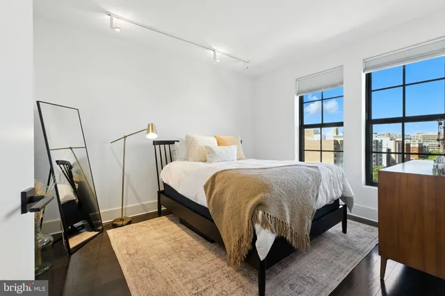 a spacious bedroom with a bed and large windows