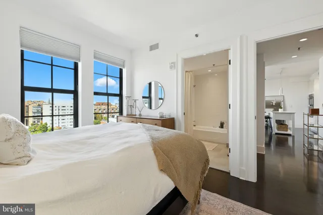 a bedroom with a bed and a large window