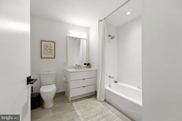 a bathroom with a bathtub toilet sink vanity and mirror