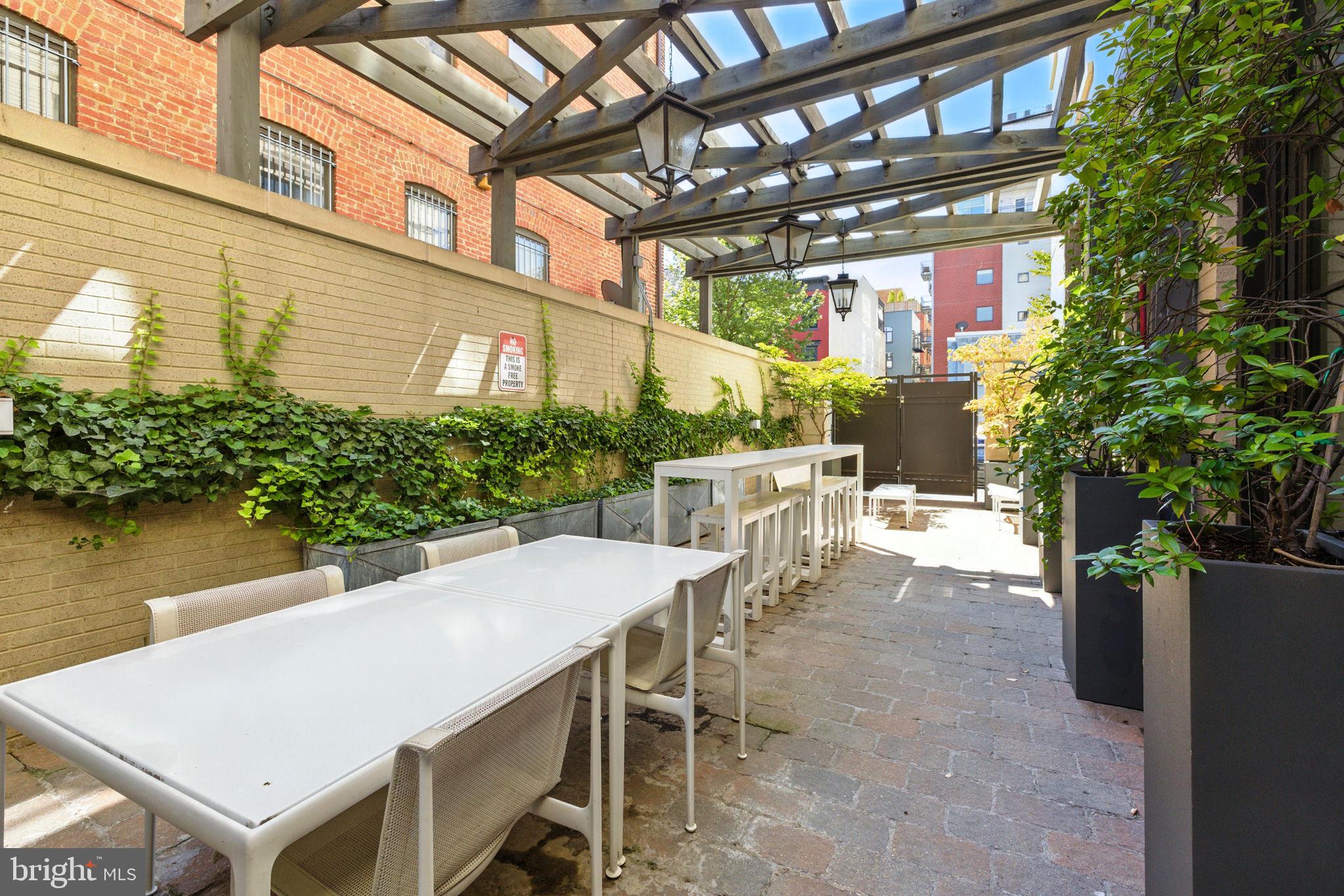 1011 M Street Northwest, Unit 901 Washington, DC 20001 - Photo 19 of 26 a view of a patio with table and chairs and potted plants