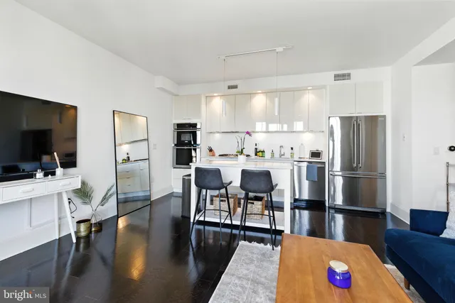 a large kitchen with a table chairs refrigerator and a stove