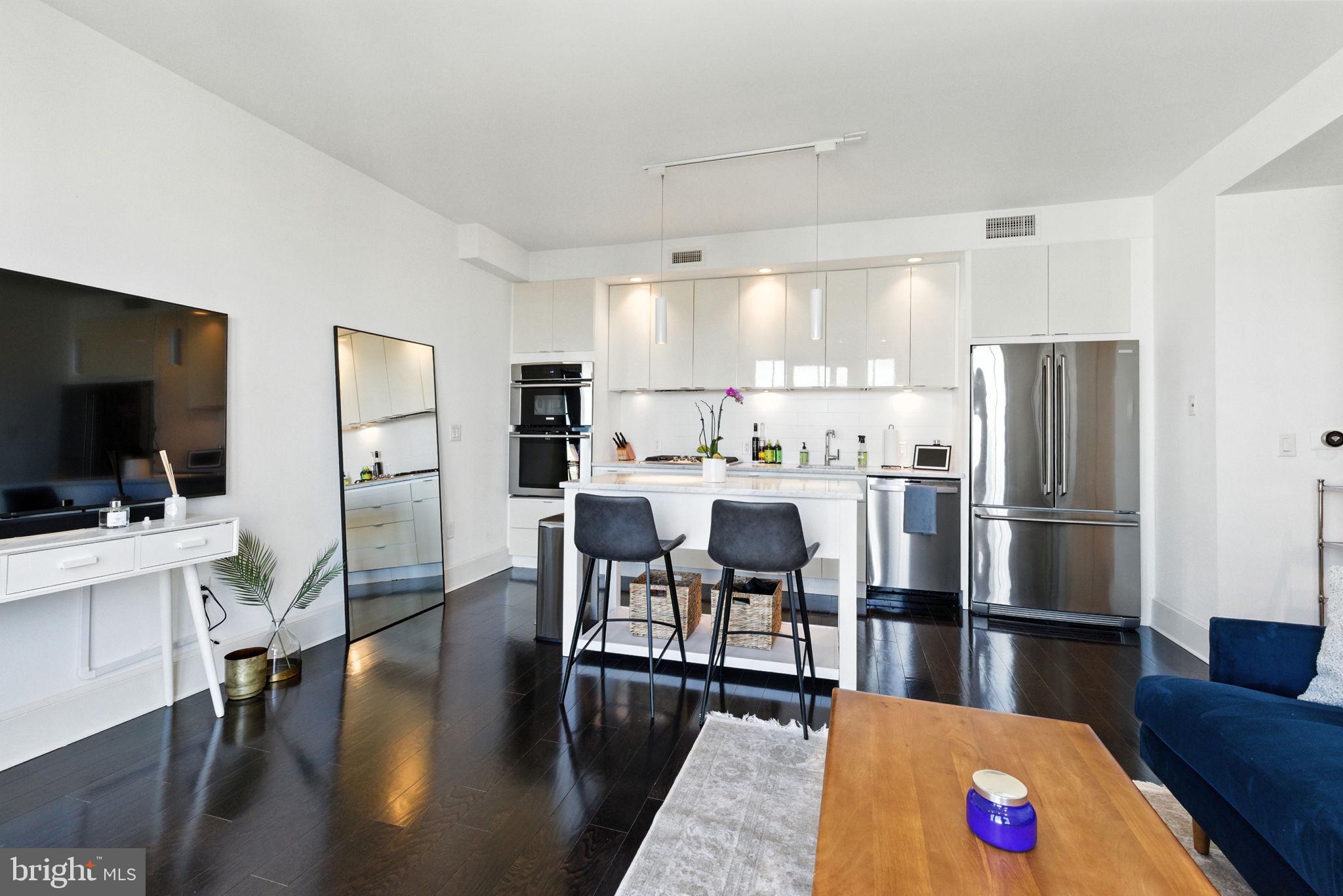 1011 M Street Northwest, Unit 901 Washington, DC 20001 - Photo 4 of 26 a large kitchen with a table chairs refrigerator and a stove