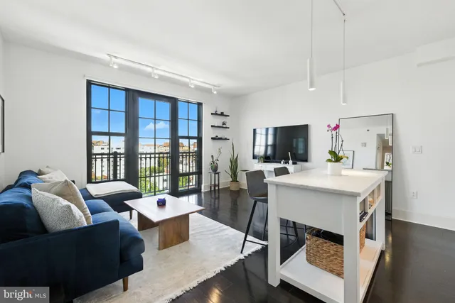 a living room with furniture a flat screen tv and a large window