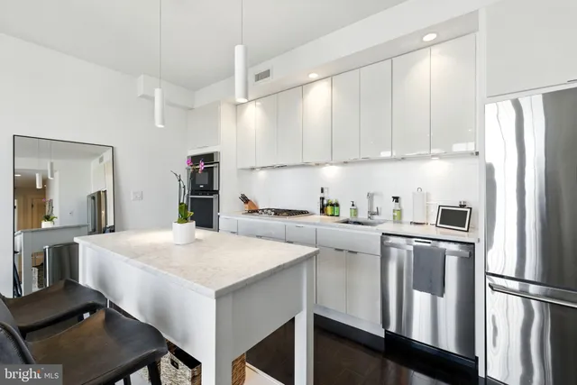 a kitchen with white cabinets and refrigerator