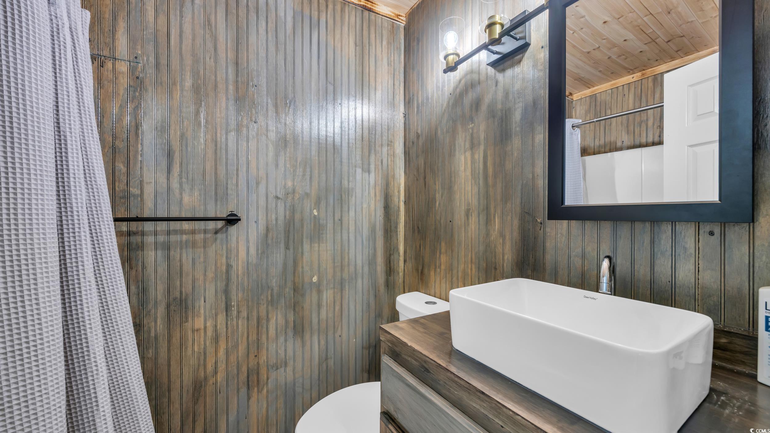 1101 Possum Trot Road, Unit C203 North Myrtle Beach, SC 29582 - Photo 3 of 29 Bathroom with toilet, wood walls, a shower with sh