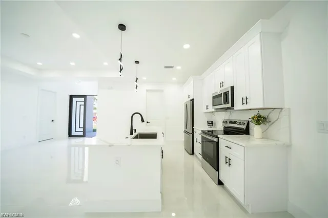 a kitchen with stainless steel appliances granite countertop a sink stove and refrigerator