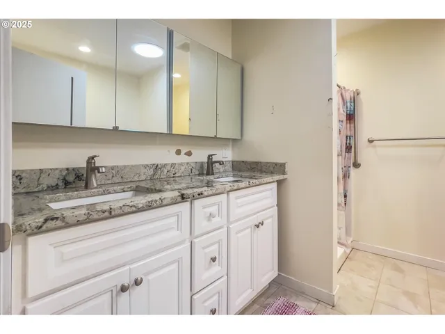 a bathroom with a granite countertop sink and a mirror