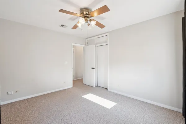 an empty room with a ceiling fan and a window