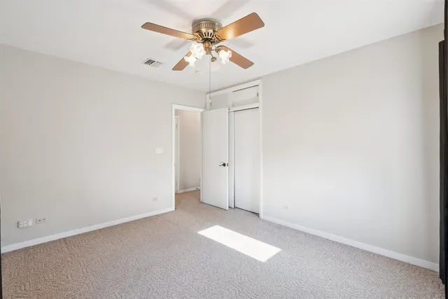 an empty room with a ceiling fan and a window