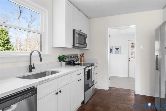 a kitchen with stainless steel appliances a sink stove top oven and refrigerator