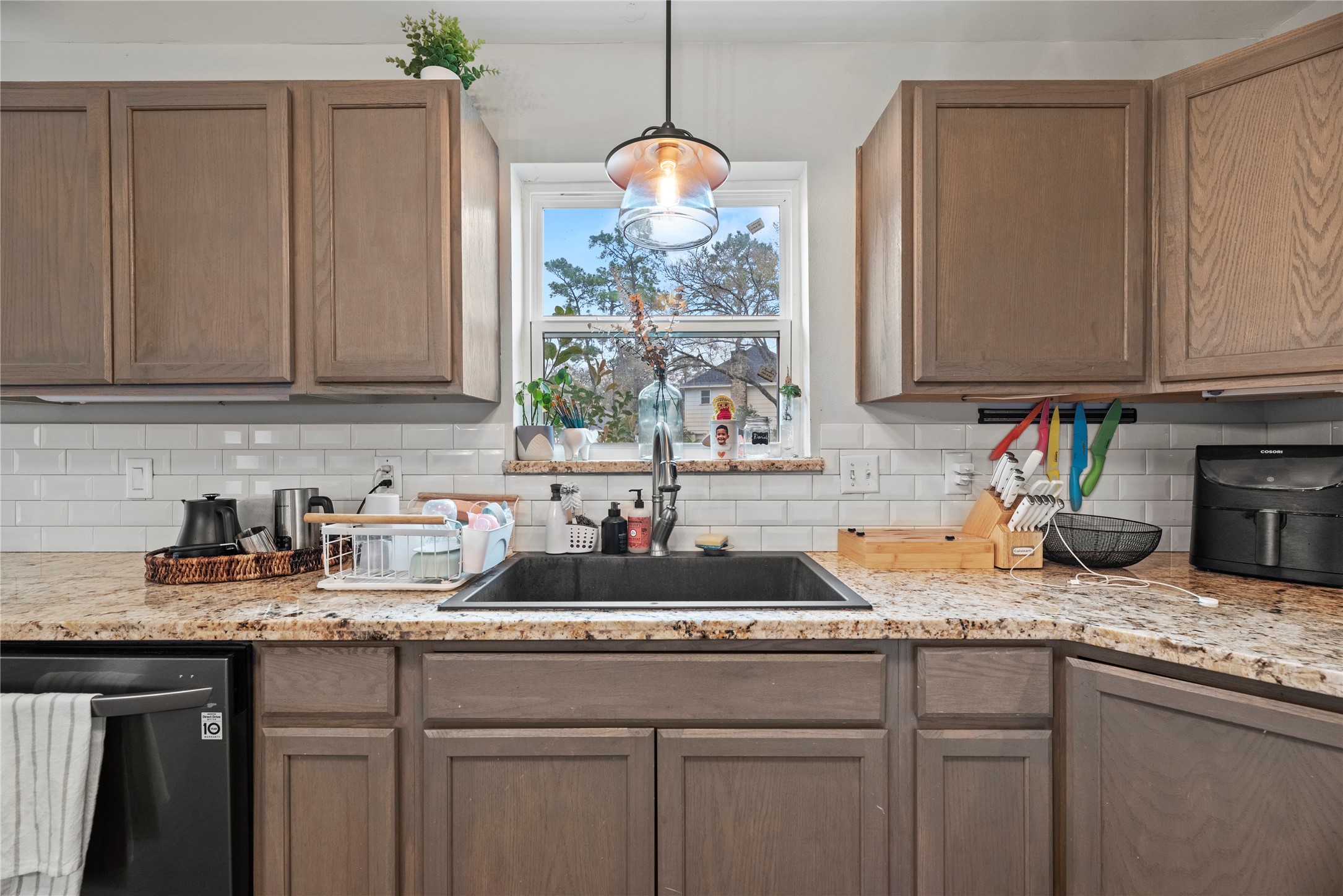 24902 Butterwick Drive Spring, TX 77389 - Photo 19 of 24 a kitchen with granite countertop a sink a stove and cabinets