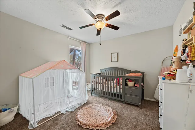 a bedroom with a baby crib a chandelier fan and a baby crib