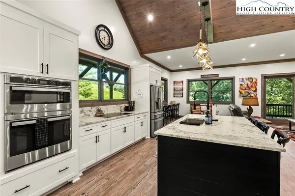 a kitchen with stainless steel appliances granite countertop a stove a sink and a microwave