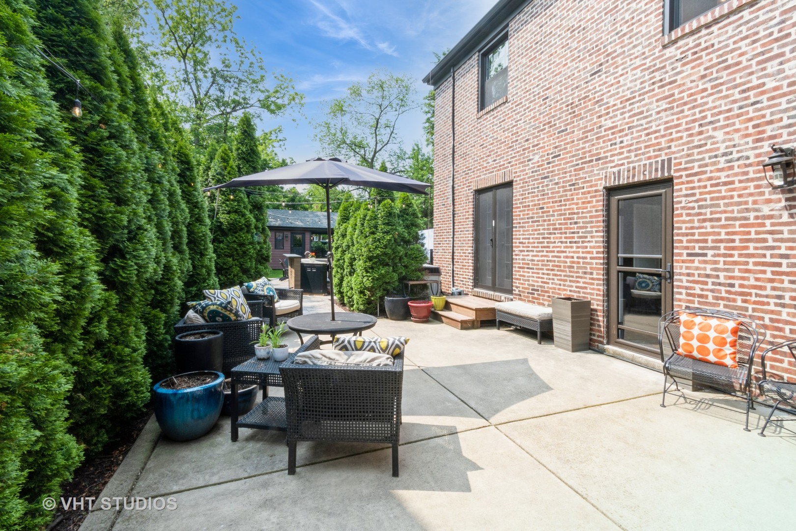 723 Gardner Road Flossmoor, IL 60422 - Photo 34 of 48 a view of a patio with a dining table and chairs under an umbrella with a fire pit