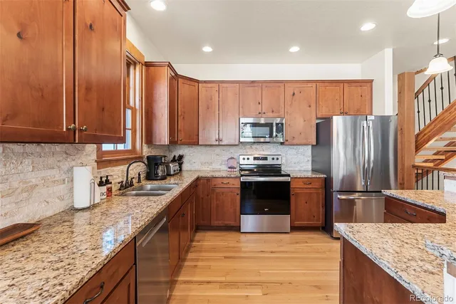 a kitchen with stainless steel appliances granite countertop a refrigerator stove and oven