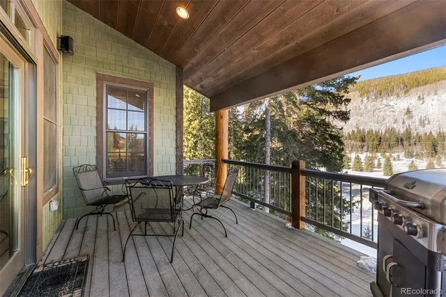 a view of a balcony with chairs and wooden floor