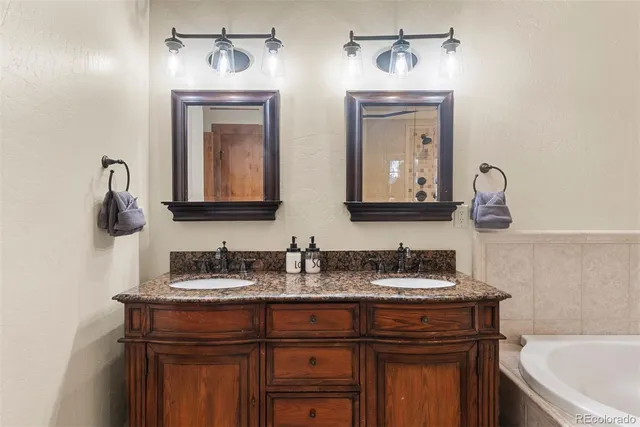 a bathroom with double sink and two mirror