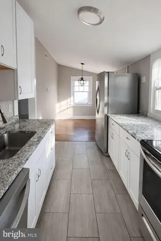 a large kitchen with a stove sink and cabinets