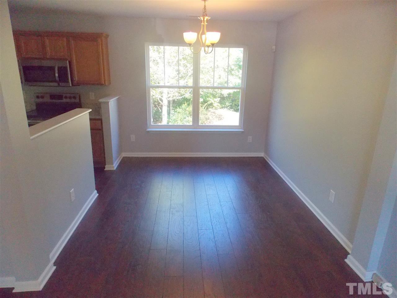 4101 Hopper Street Raleigh, NC 27616 - Photo 6 of 12 an empty room with wooden floor a exposed radiator and a window