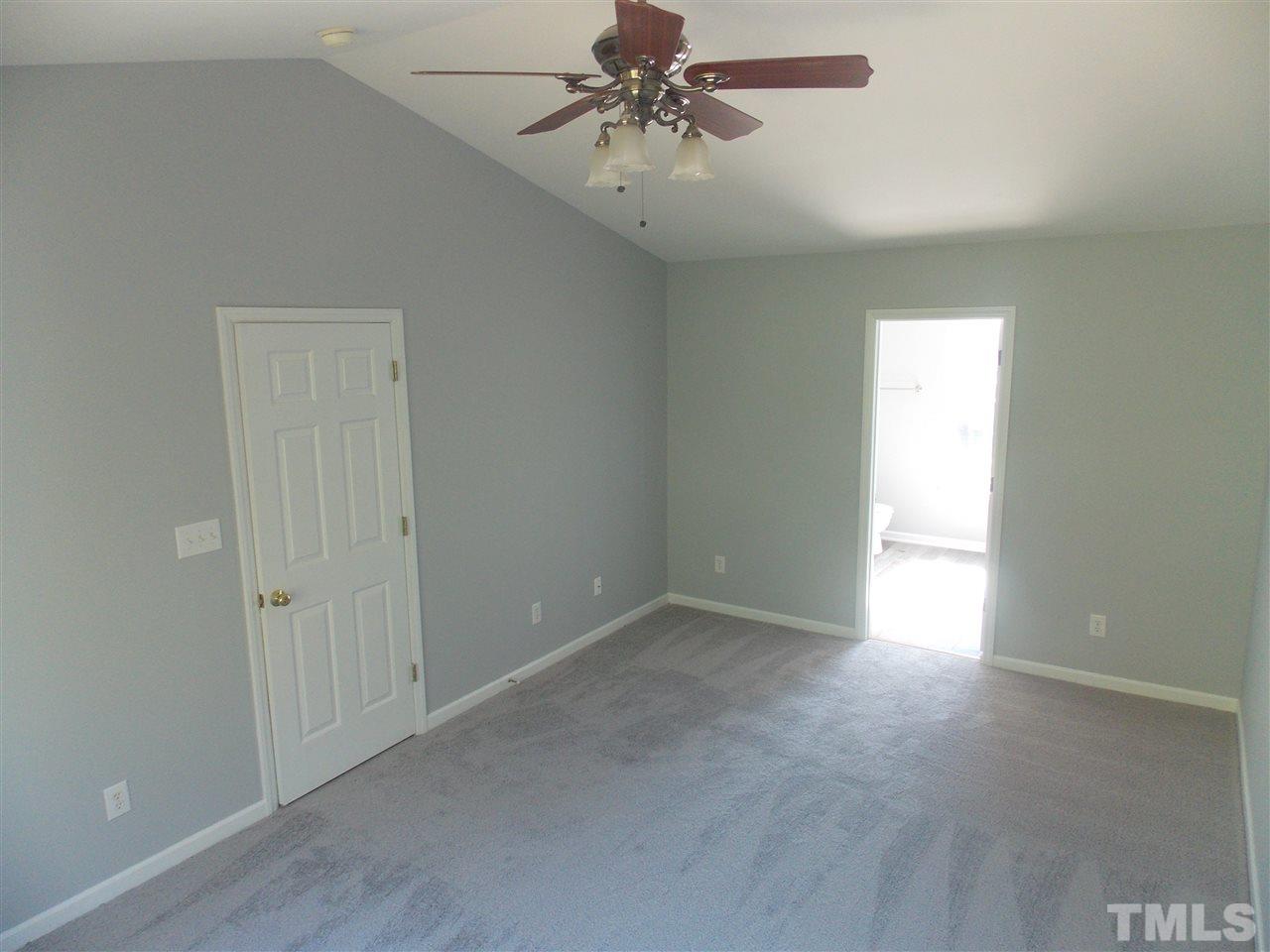4101 Hopper Street Raleigh, NC 27616 - Photo 8 of 12 an empty room with chandelier fan and windows