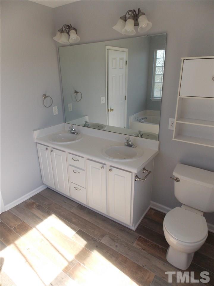 4101 Hopper Street Raleigh, NC 27616 - Photo 10 of 12 a bathroom with a granite countertop toilet sink and mirror
