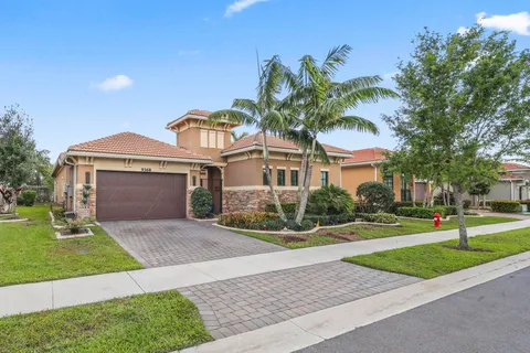 a front view of a house with a yard and potted plants