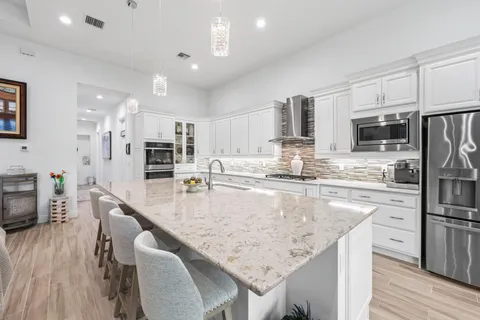 a large kitchen with stainless steel appliances kitchen island granite countertop a sink and cabinets