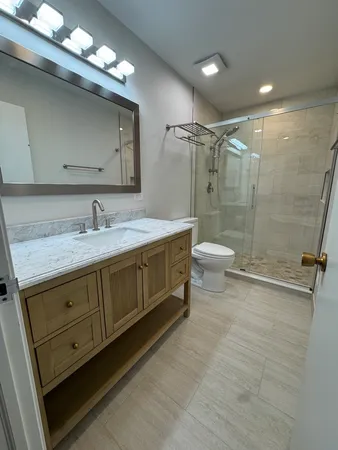 a bathroom with a double vanity sink toilet and shower