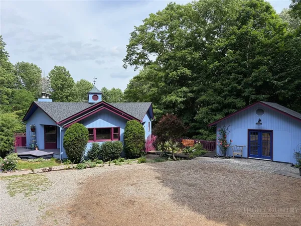 a view of a house with a yard and large tree