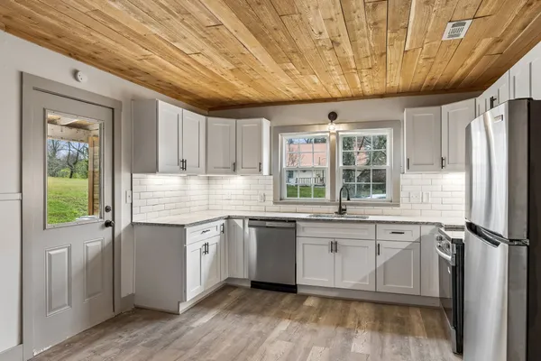 a kitchen with granite countertop a sink stainless steel appliances and cabinets