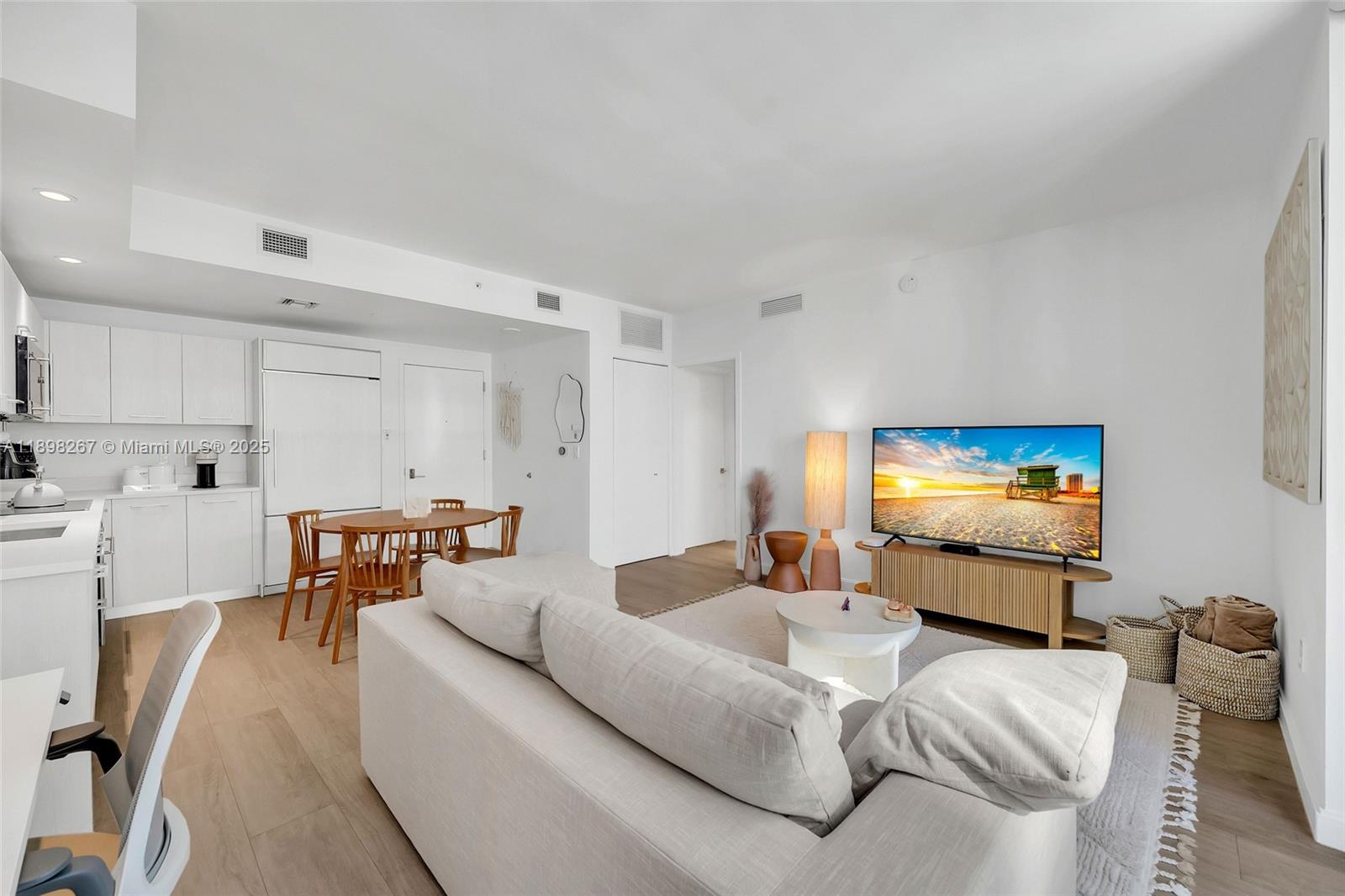 55 Southwest 9th Street, Unit 1802 Miami, FL 33130 - Photo 2 of 35 a living room with furniture and a flat screen tv