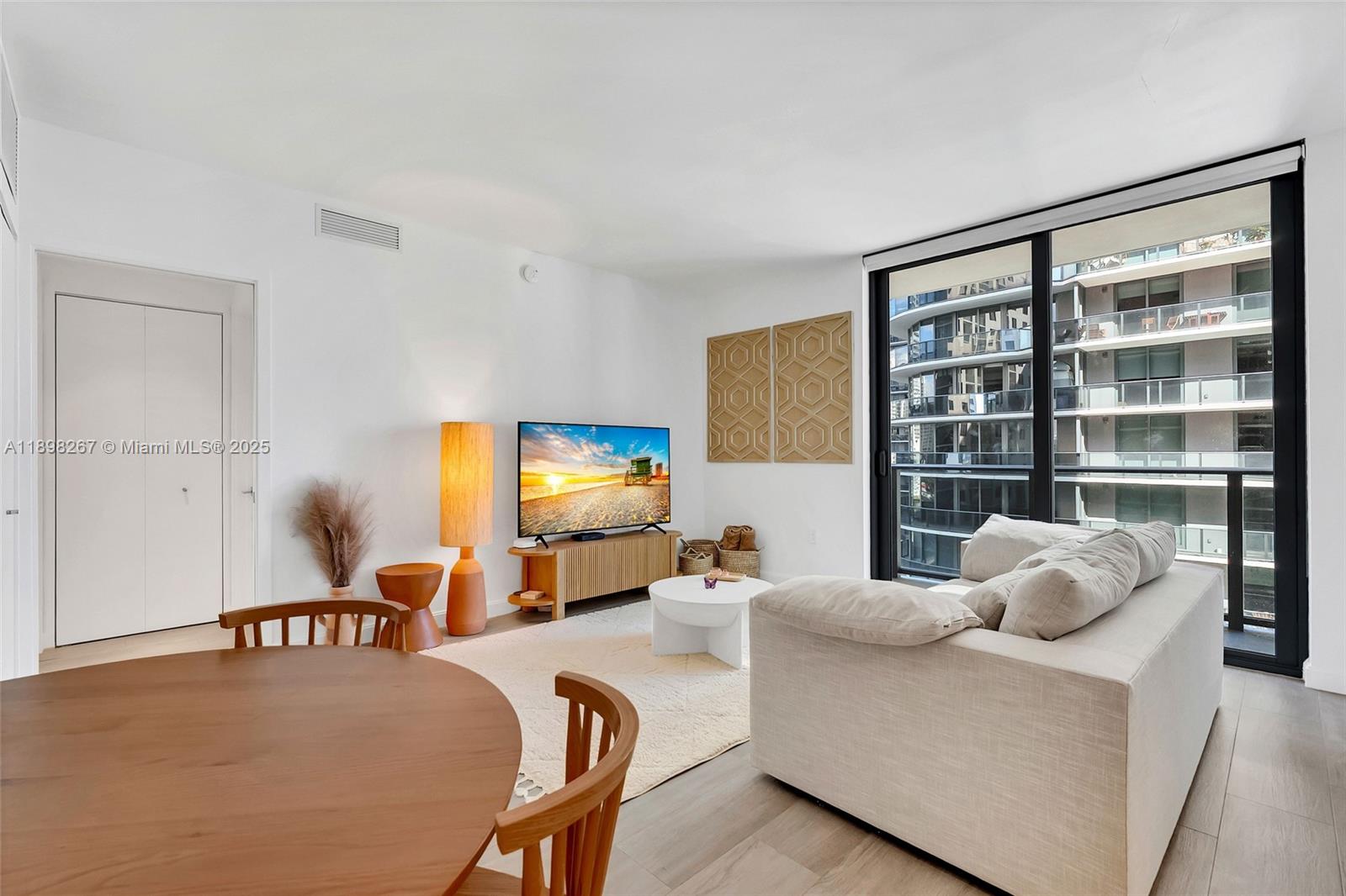55 Southwest 9th Street, Unit 1802 Miami, FL 33130 - Photo 3 of 35 a living room with furniture and a flat screen tv