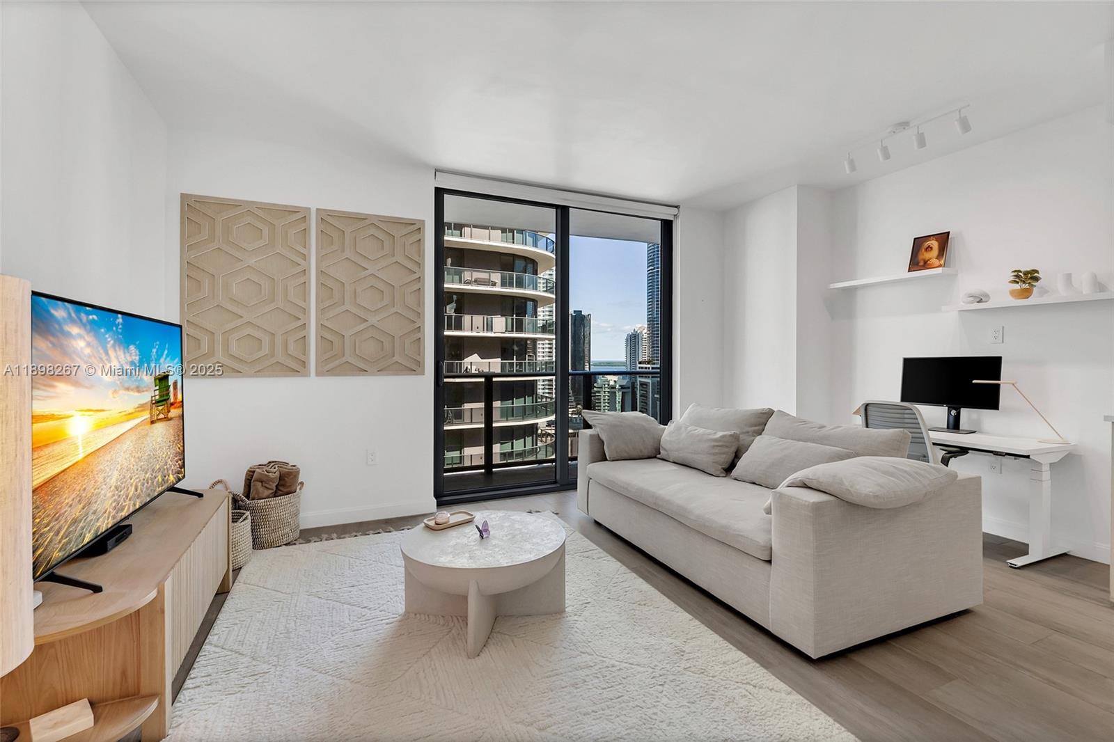 55 Southwest 9th Street, Unit 1802 Miami, FL 33130 - Photo 7 of 35 a living room with furniture and a flat screen tv