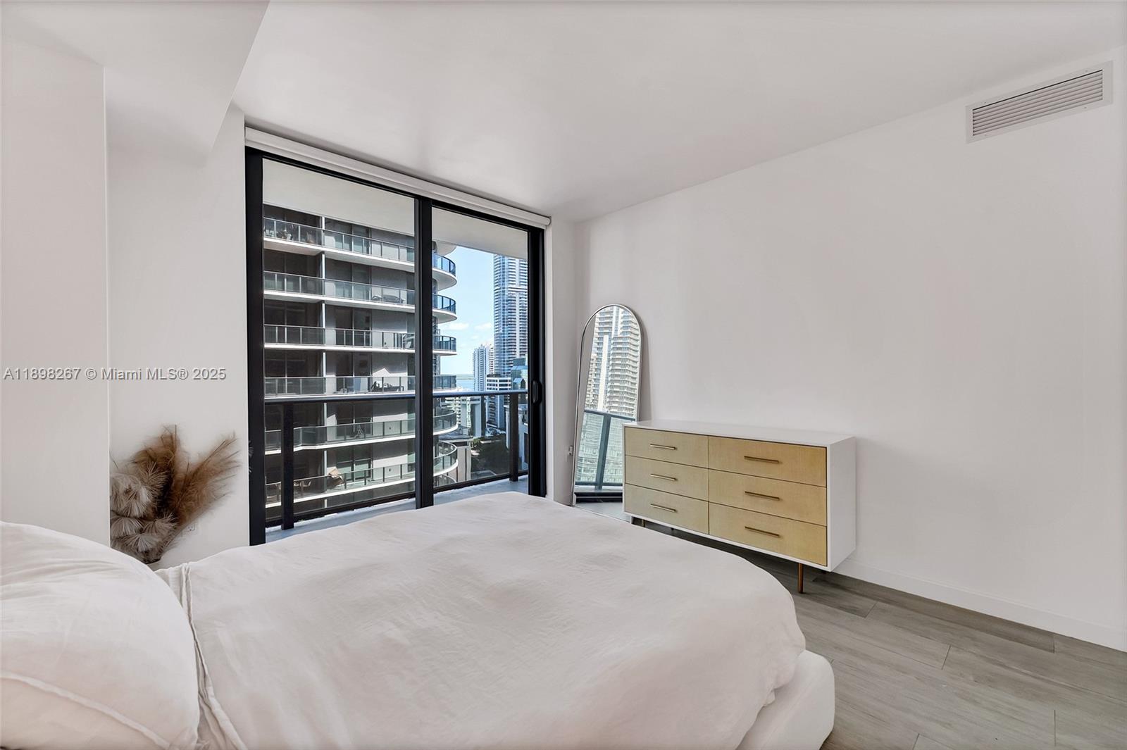 55 Southwest 9th Street, Unit 1802 Miami, FL 33130 - Photo 9 of 35 a bedroom with a bed and a dresser